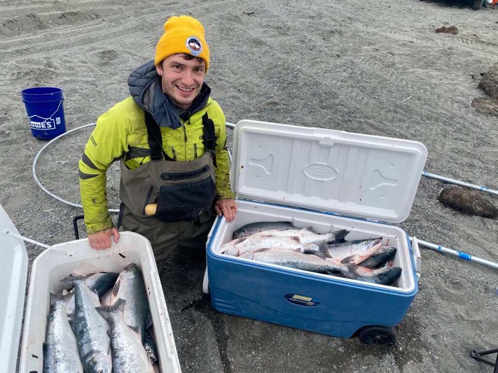 Young man with fish in cooler